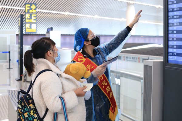 疫情期間，重慶機場安全檢查站黨員為旅客提供服務。重慶機場集團供圖