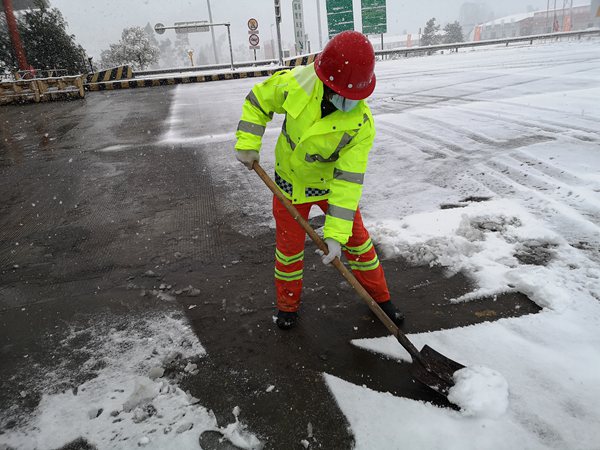 12月26日10點20分渝湘高速玉屏收費站養護人員對收費站外廣場進行積雪清除。 重慶高速集團供圖
