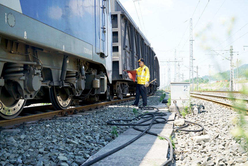 重慶西車輛段貨車檢車員正在插設紅旗準備作業。江堯攝
