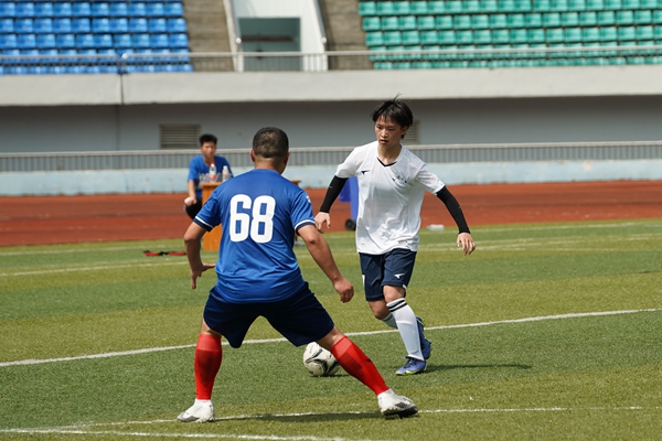 馬慶林（白衣者）帶球突破。石柱縣委宣傳部供圖