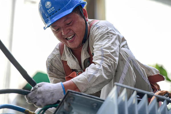 7月13日，國網合川供電公司員工在10千伏皂蟠線公園路中人2號臺區搶險配變。秦曉東攝