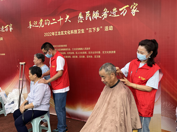 青年志愿者為老人公益剪發、按摩。蔣海濤攝