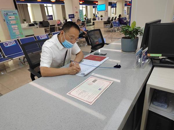 辦事群眾在縣政務服務大廳領取農房抵押《不動產登記證明》。秀山縣委宣傳部供圖