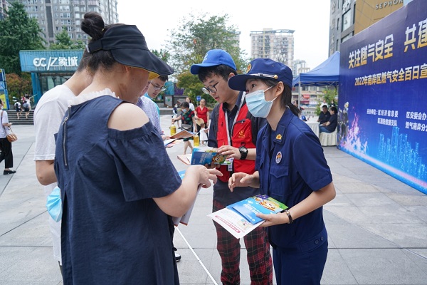 宣傳人員向過往市民講解燃氣安全知識。南岸區消防救援支隊供圖