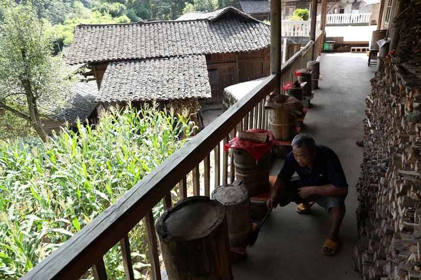 小寨居民打理家門口的蜂桶。楊敏攝