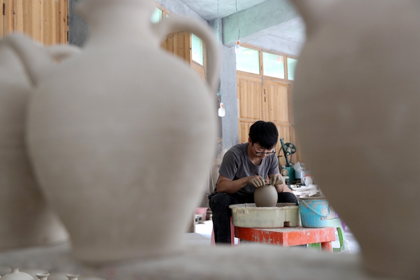 羅達川在給陶坯造型。黔江區委宣傳部供圖