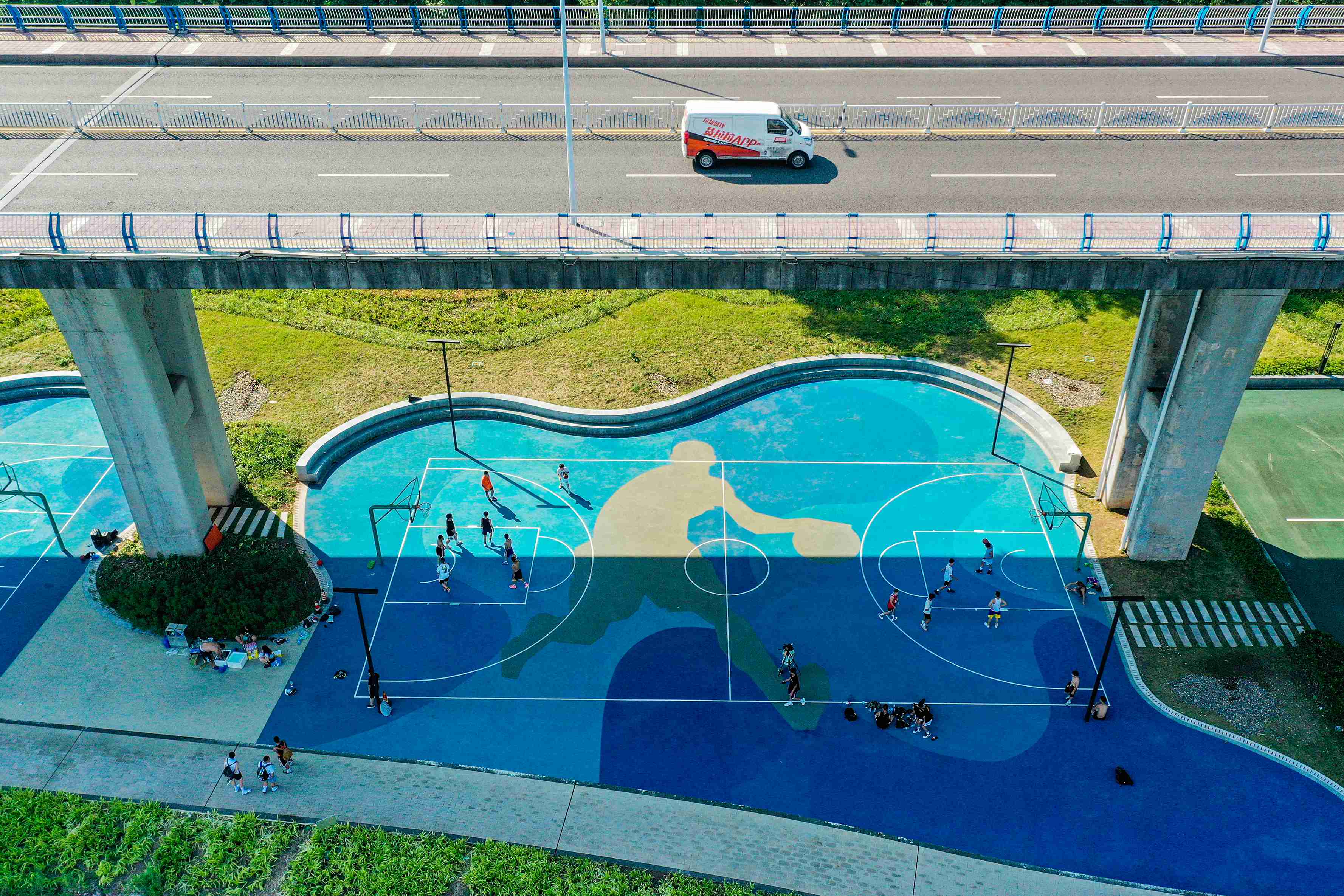 在渝中區黃沙溪大橋下，市民在長江邊的籃球場打球。何超攝