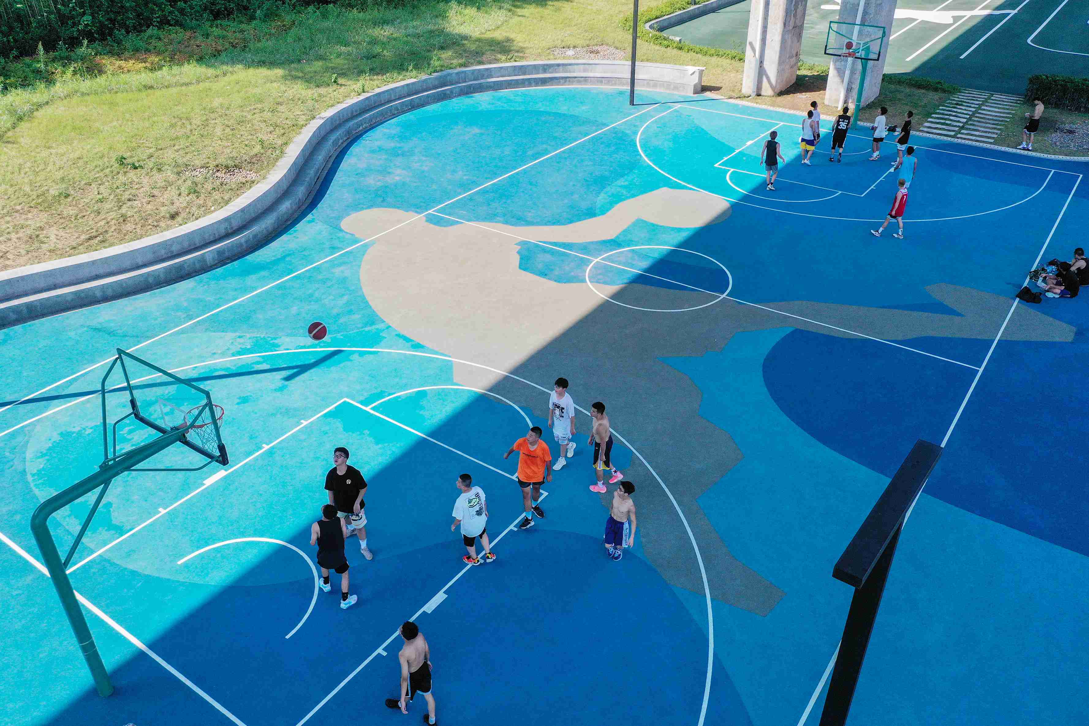 在渝中區黃沙溪大橋下，市民在長江邊的籃球場打球。何超攝