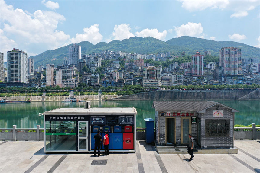 在彭水苗族土家族自治縣南濱路生活垃圾分類服務驛站，管理員給市民講解垃圾分類知識。楊敏攝