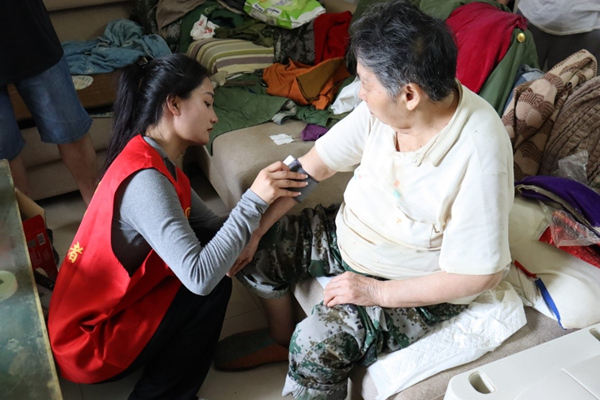 志愿者為老人測量血壓。李雪攝