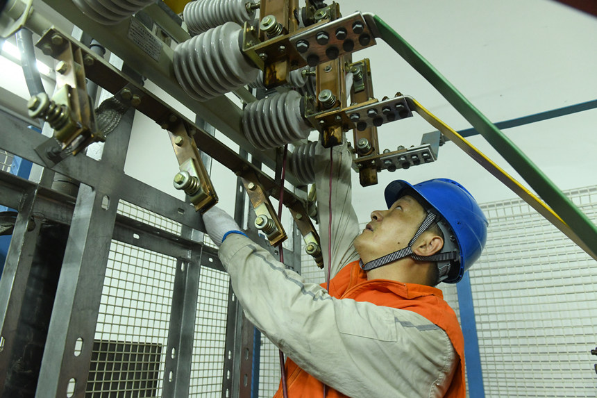8月10日晚，國家電網紅巖（璧山運檢）共產黨員服務隊隊員在110千伏大路變電站檢修3號電容器。周毅攝