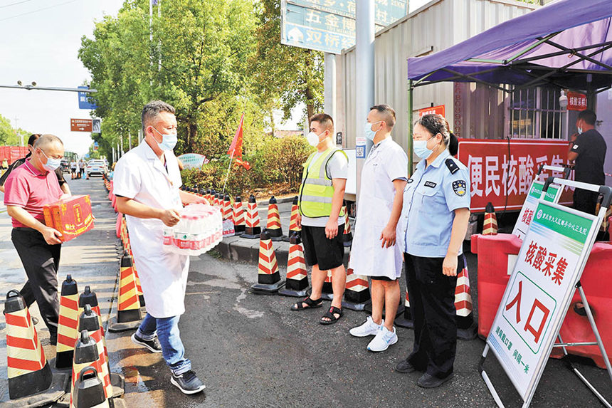 8月16日，成渝高速公路大足郵亭站核酸檢測點，郵亭鎮工作人員送來防暑降溫藥品、飲料等，保護核酸檢測點工作人員身心健康。通訊員 譚顯全 攝/視覺重慶