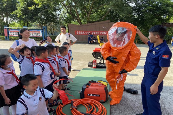 消防員向師生演示消防服的穿戴方法。渝北區消防救援支隊供圖