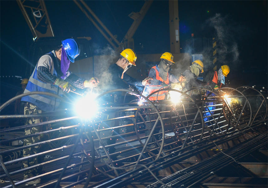 工作人員正在進行夜間鋼筋電焊作業。郭旭攝