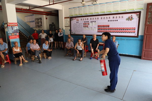 消防宣傳員向群眾講解滅火器的使用方法。秀山縣消防救援大隊供圖