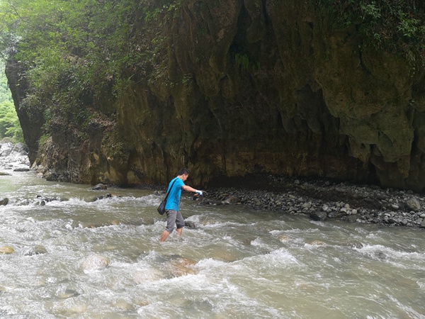 《過河》。6月30日，在巫山縣竹賢鄉下莊村谷底峽谷，川東南地質大隊地災駐守隊員龔強蹚水過河到對面的地質災害點進行調查。易洪志攝