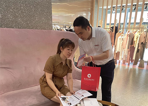 重慶農商行武隆支行客戶經理向周女士介紹創業擔保貸款相關政策。重慶農商行供圖