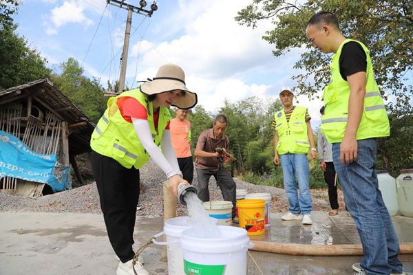 秀山縣應急管理局黨員先鋒突擊隊隊員正在為村民接水。任燕攝