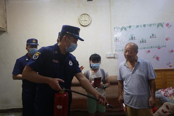 消防宣傳員為居民示范滅火器的使用方法。渝中區消防救援支隊供圖