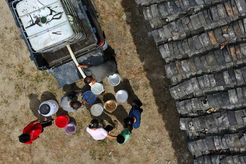 村民在送水車前接水。楊敏攝