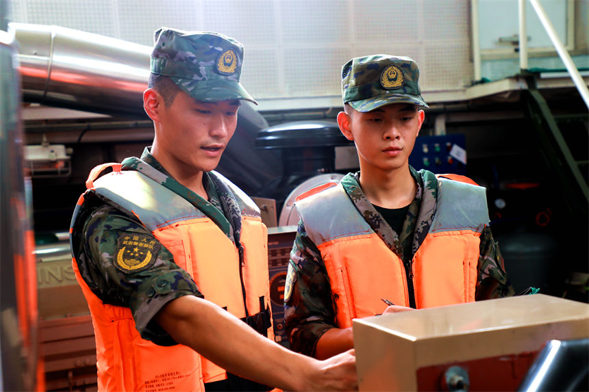 老兵為戰友講解船艇機器參數。錢云星攝