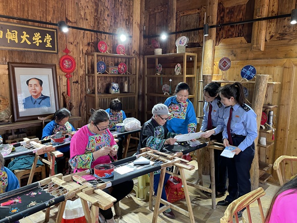 酉陽縣稅務局工作人員走進酉陽縣子月苗族文化傳播有限責任公司，向苗繡職工講解組合式稅費支持政策。 邱冰攝