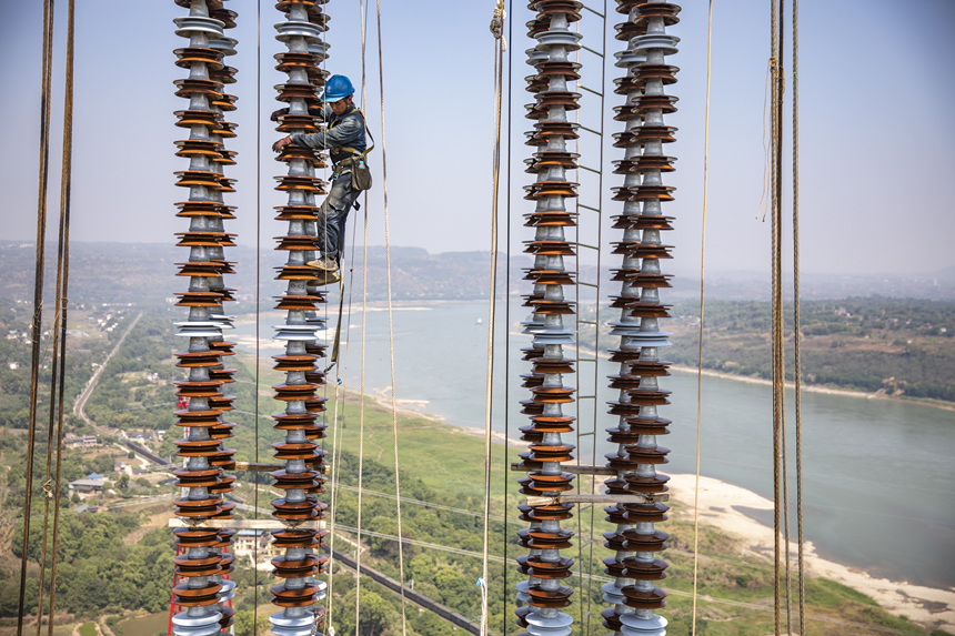 9月13日，在重慶市江津區白浙線長江大跨越施工現場，施工人員正在攀爬絕緣子串。黃偉攝
