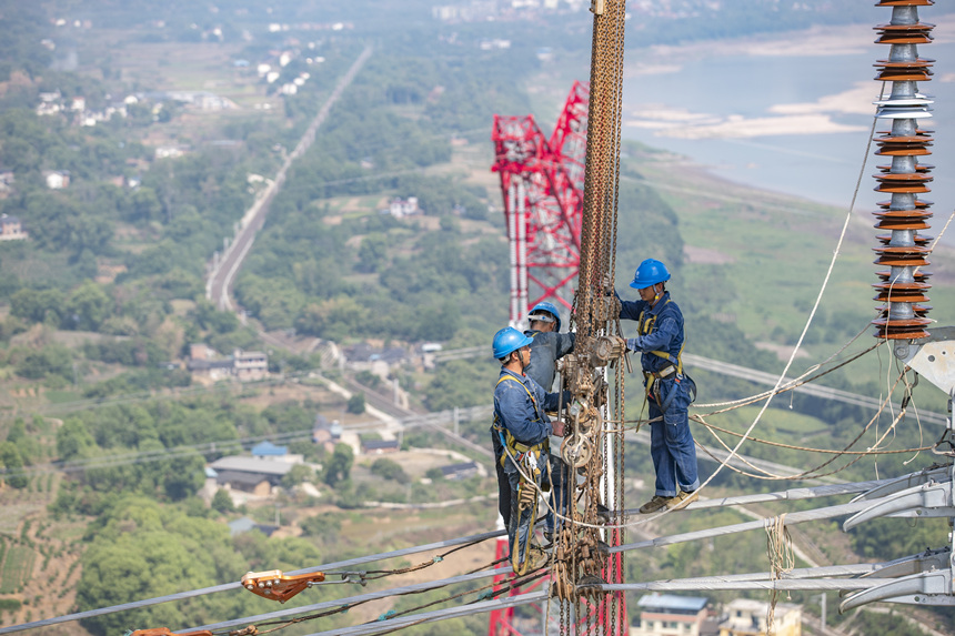 9月13日，在重慶市江津區白浙線長江大跨越施工現場，施工人員正在進行導線附件安裝。黃偉攝