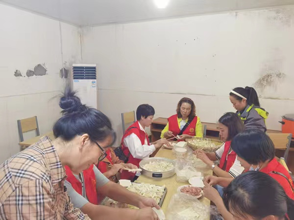 志愿者正忙著給老人準備包子、餃子等食物。李雄偉攝