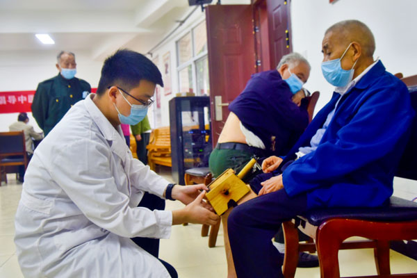 為老人進行艾灸治療。陶涵攝