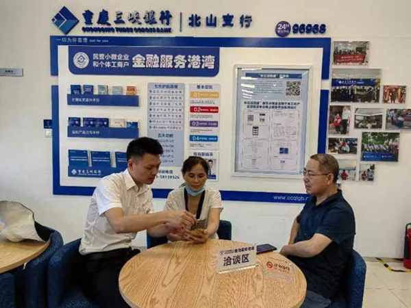 重慶三峽銀行北山支行金融服務港灣工作人員為前來咨詢的個體工商戶介紹普惠金融產品及政策。重慶三峽銀行 供圖