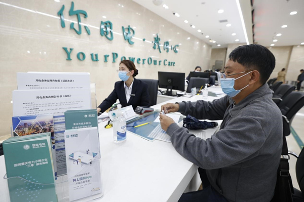 國網重慶電力員工在南坪供電營業廳為客戶辦理用電業務。龔超攝