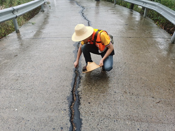 《李家溝滑坡裂縫調查》。9月上旬，重慶地研院駐守地質隊員陳念在雨中巡查奉節縣李家溝滑坡，調查滑坡變形裂縫發展情況。茍青松攝