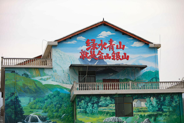 洪安鎮平馬社區印有綠水青山就是金山銀山的彩繪墻。胡程攝