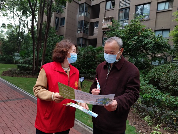 垃圾分類宣傳員給小區居民講解垃圾分類知識。