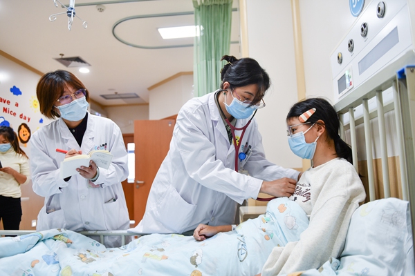 感染科主任醫師張禎禎（中）檢查住院患者情況。鄒樂攝