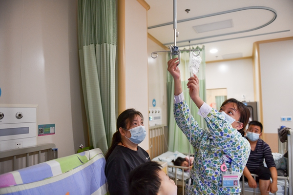 感染科護士（中）為患者進行日常治療。鄒樂攝