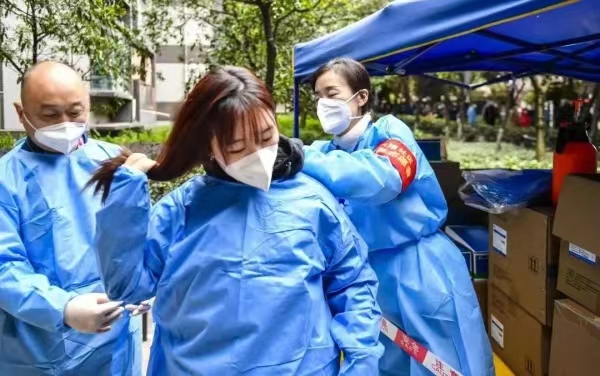 父女倆為參與防控工作做準備。南岸區融媒體中心供圖