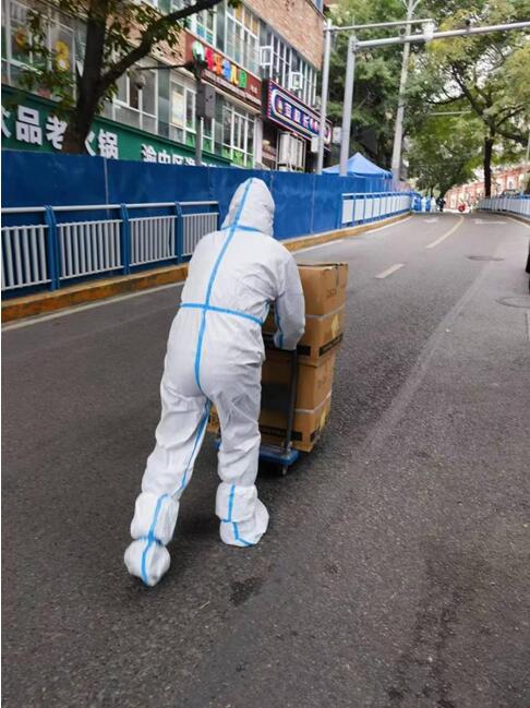 巴渝民宿集團所屬渝地物業公司嘉和苑項目工作人員配合社區運送醫療物資。渝地物業供圖