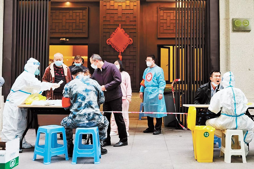 沙坪壩區退役軍人紅巖志愿服務隊為小區居民采集核酸樣本。（沙坪壩區退役軍人事務局供圖）