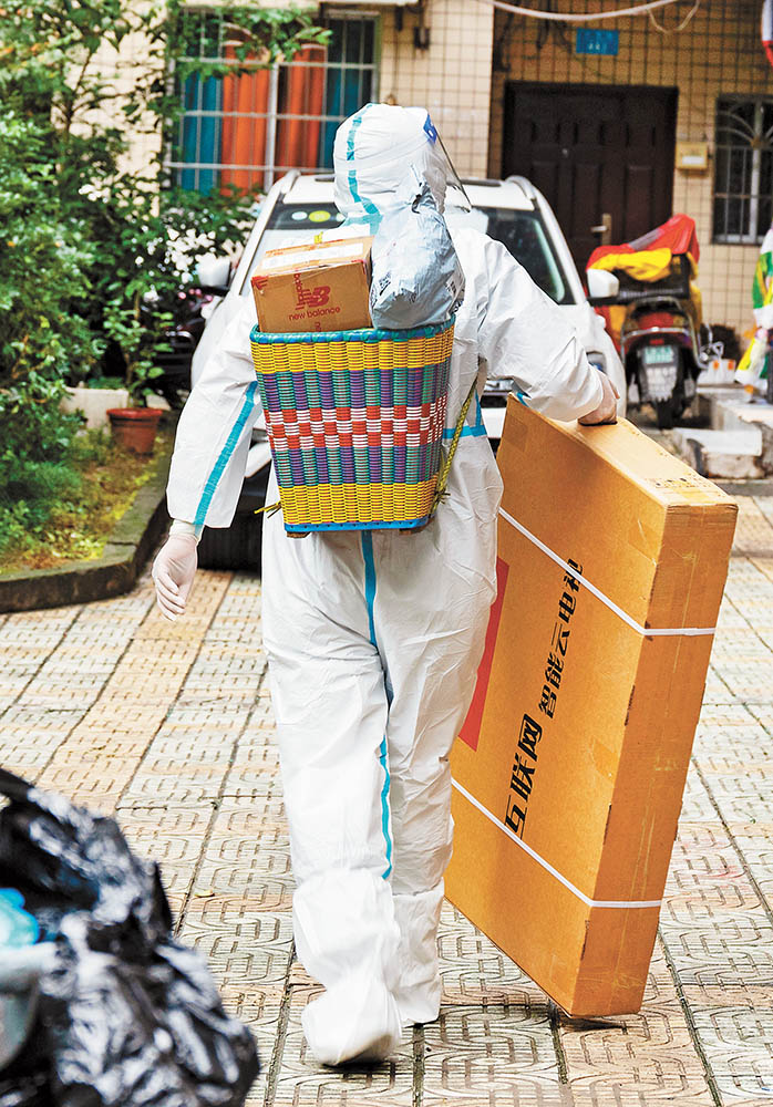 11月14日，萬州區雙堰塘社區，山東籍“95后”志愿者王德全為居民送物資。特約攝影 冉孟軍視覺重慶