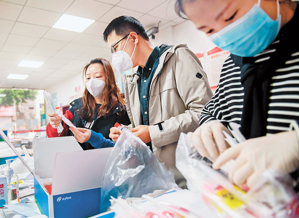 11月14日，渝北區龍山街道龍山路社區，“追陽專班”黨員、“95后”志愿者張思源(中)和同事正在準備上門復核核酸采樣的各種物資。記者 崔力 攝 視覺重慶