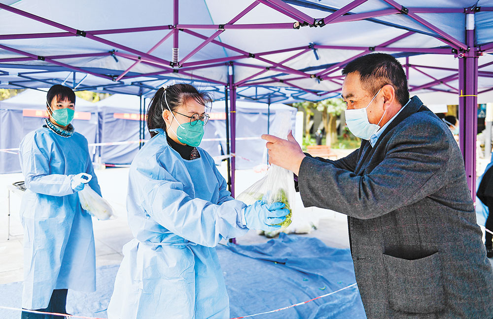 11月17日，兩江新區翠云街道翠渝路社區，尚格博園小區，周洋(中)正在給小區居民派送蔬菜。記者 齊嵐森 攝 視覺重慶