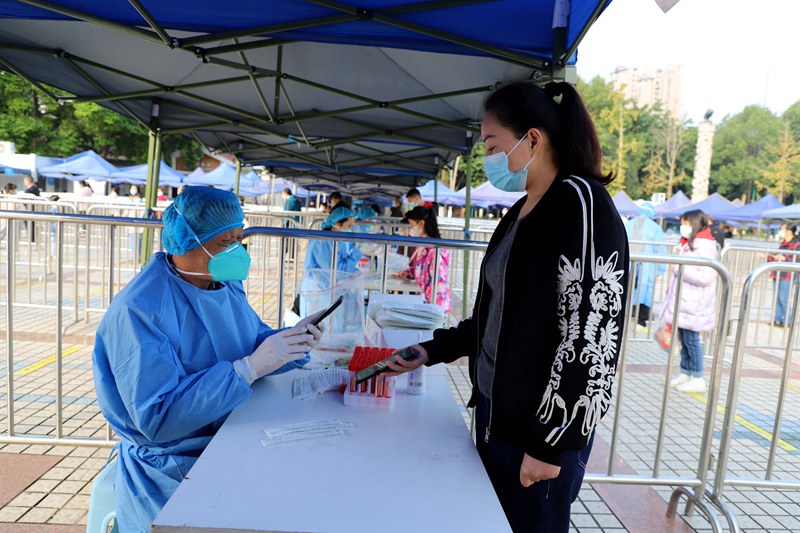 11月16日，張家才在大足區宏聲廣場核酸采樣點進行信息錄入工作。通訊員 譚顯全 攝