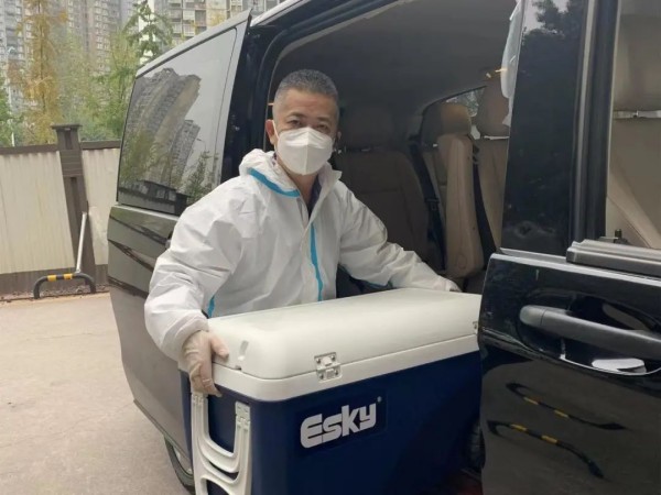 盧行正在往車上搬運物資。