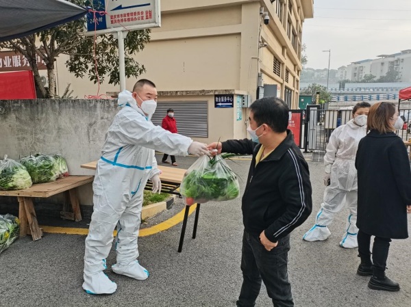 物業工作人員向居民發放蔬菜包?？蹬d路社區供圖