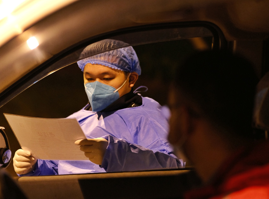 經開區通盛工業園區，經開區志愿者在園區路口檢查通行證，保障園區安全生產。郭旭 攝