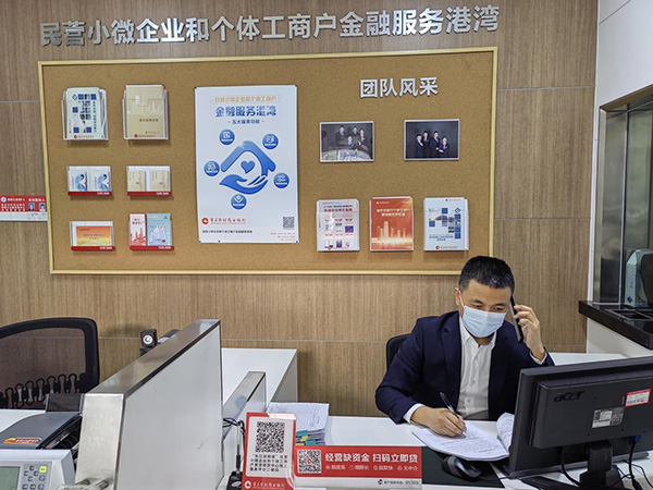 重慶農商行江津分行客戶經理王勝電話指導客戶通過“云簽約”辦理貸款手續。重慶農商行供圖