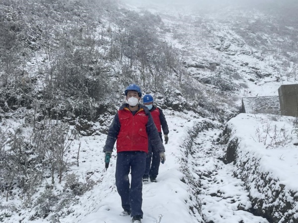 11月30日，國網城口供電公司員工踩著積雪巡視檢查10千伏廟羅線。王成躍攝
