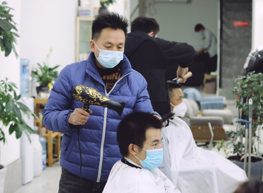 在沙坪壩區覃家崗步行街，一理發店為市民提供服務。郭思云攝